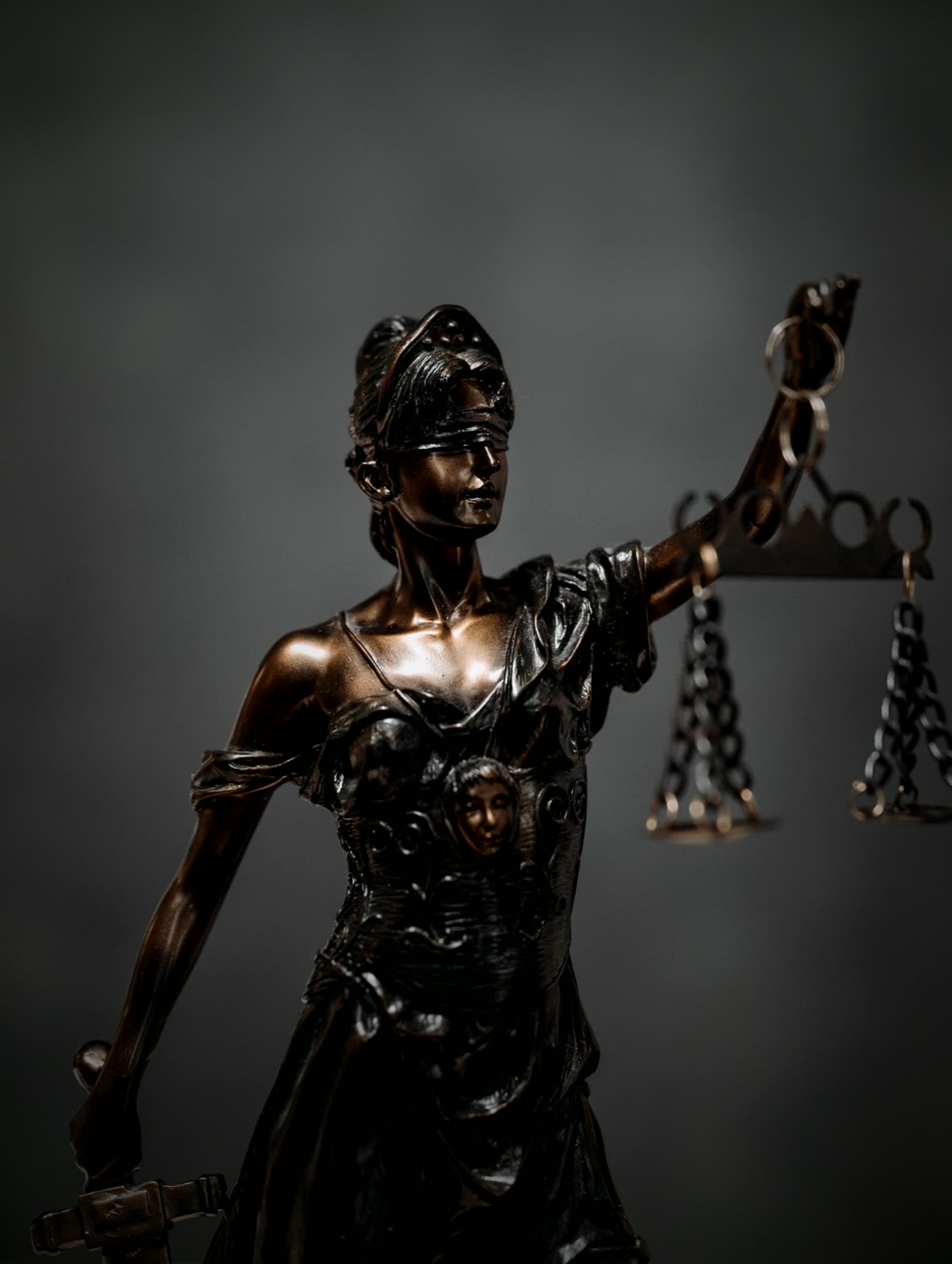 Estátua da Justiça em bronze, de olhos vendados, segurando a balança